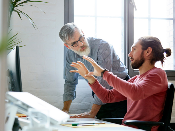 Businessman Sharing Ideas With Colleague In Office