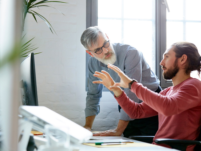 Businessman Sharing Ideas With Colleague In Office