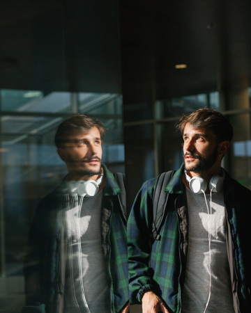 Young Man Reflected In A Glass Wall